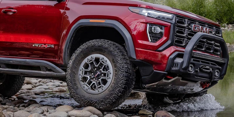 2026 GMC Canyon Elevation driving over rocky off-road terrain