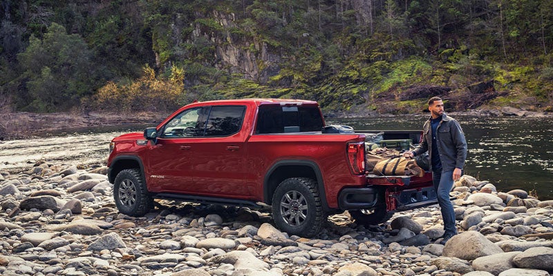 2026 GMC Sierra 1500 AT4X with MultiPro Tailgate at a riverside campsite