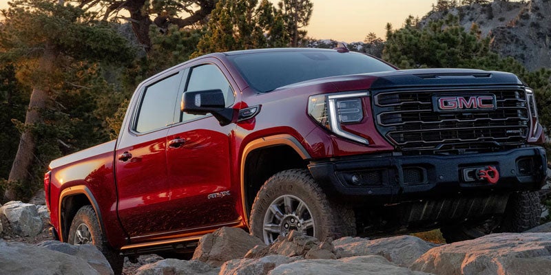 2026 GMC Sierra 1500 AT4X climbing over rocky off-road terrain